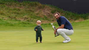 Scottie Scheffler of the U.S. celebrates with his son Bennett and the Claret Jug trophy after winning The 153rd Open Championship