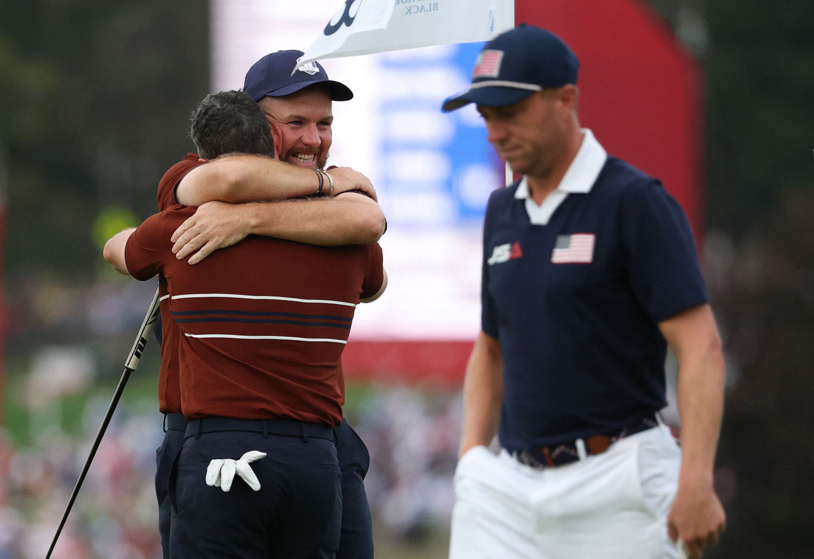 Lowry and McIlroy embrace in front of Thomas