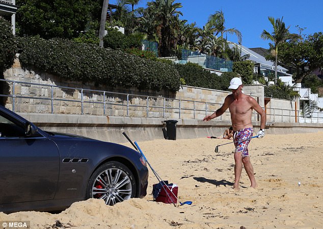 Maserati driver parks on beach to play golf and pump Bob Marley!
