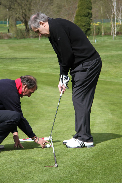 Using the flagstick to keep the putter head square
