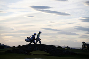 Oosthuizen and his caddie tackle the Swilcan Bridge on day three