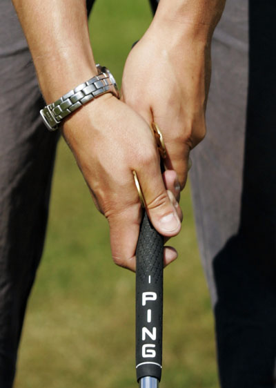 No pressure: a neutral grip, also showing tokens between thumb and forefinger in parallel towards right shoulder.
