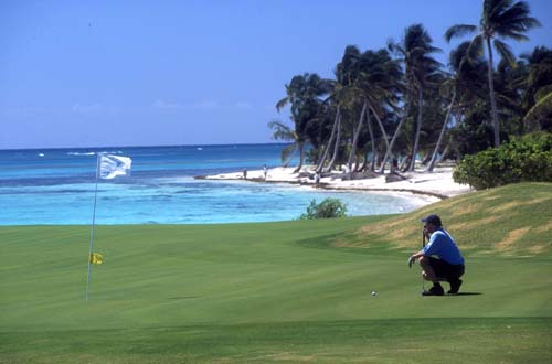 A golfer lines up a putt on the gorgeous 18th green, Punta Cana course.