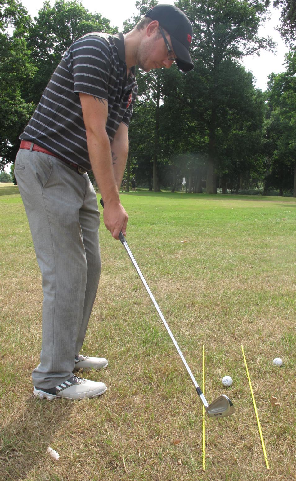 Use alignment markers or golf clubs to help you with the line of your chipping