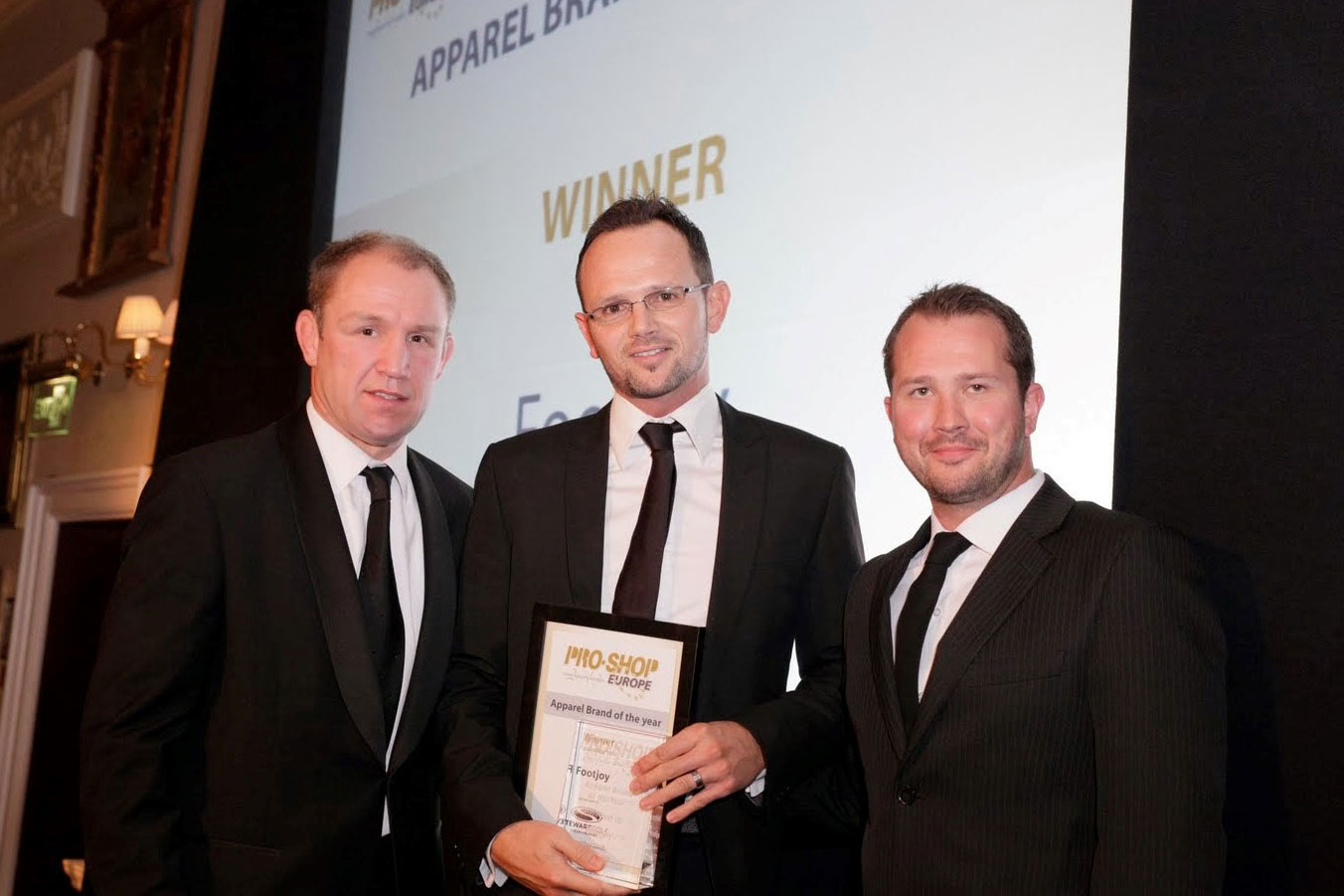 Russell Lawes (centre), collects the award from Rugby World Cup winner Neil Back 