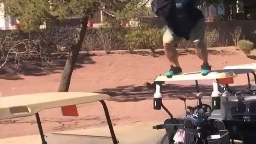 Guy jumps off a golf cart onto another in epic golf fail...