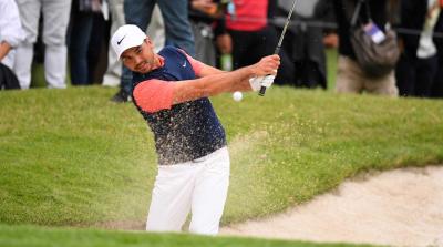 Jason Day splashes out of a greenside bunker with a 6 iron