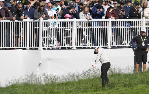 Rory McIlroy plays after taking a drop from the hospitality area